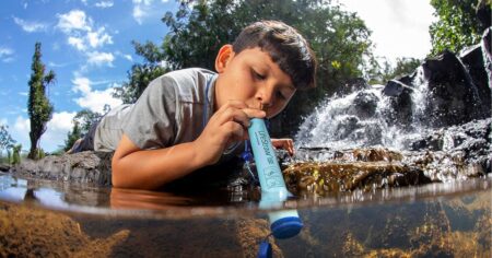 boy drinking from a Lifestraw