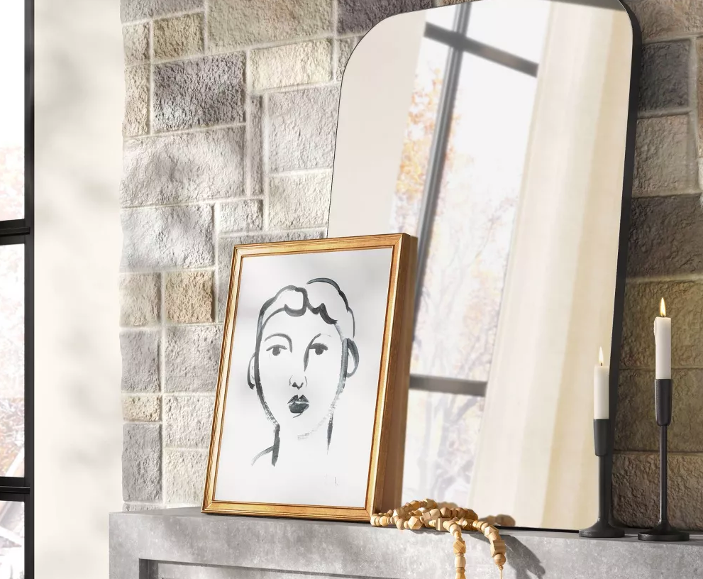 picture leaning on a mirror on a mantle