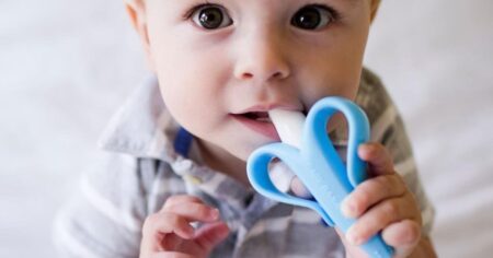 baby holding a toothbrush