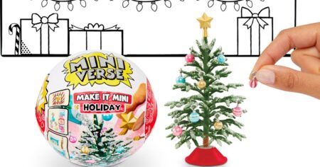 hand decorating a mini Christmas tree