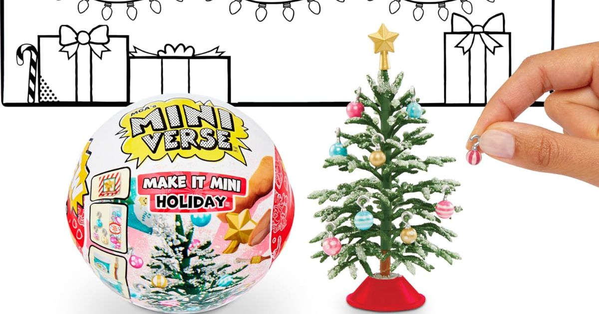 hand decorating a mini Christmas tree