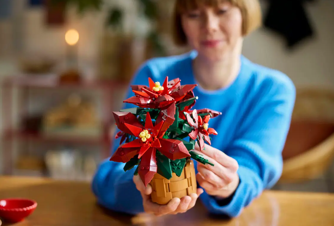 Poinsettia woman holding a LEGO Poinsettia