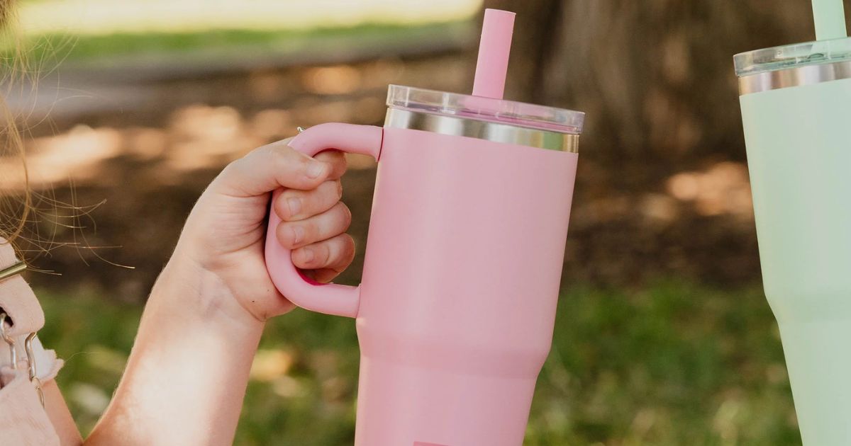 hand holding a travel tumbler