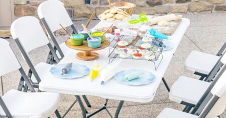 folding table with cupcake deocrating supplies on it