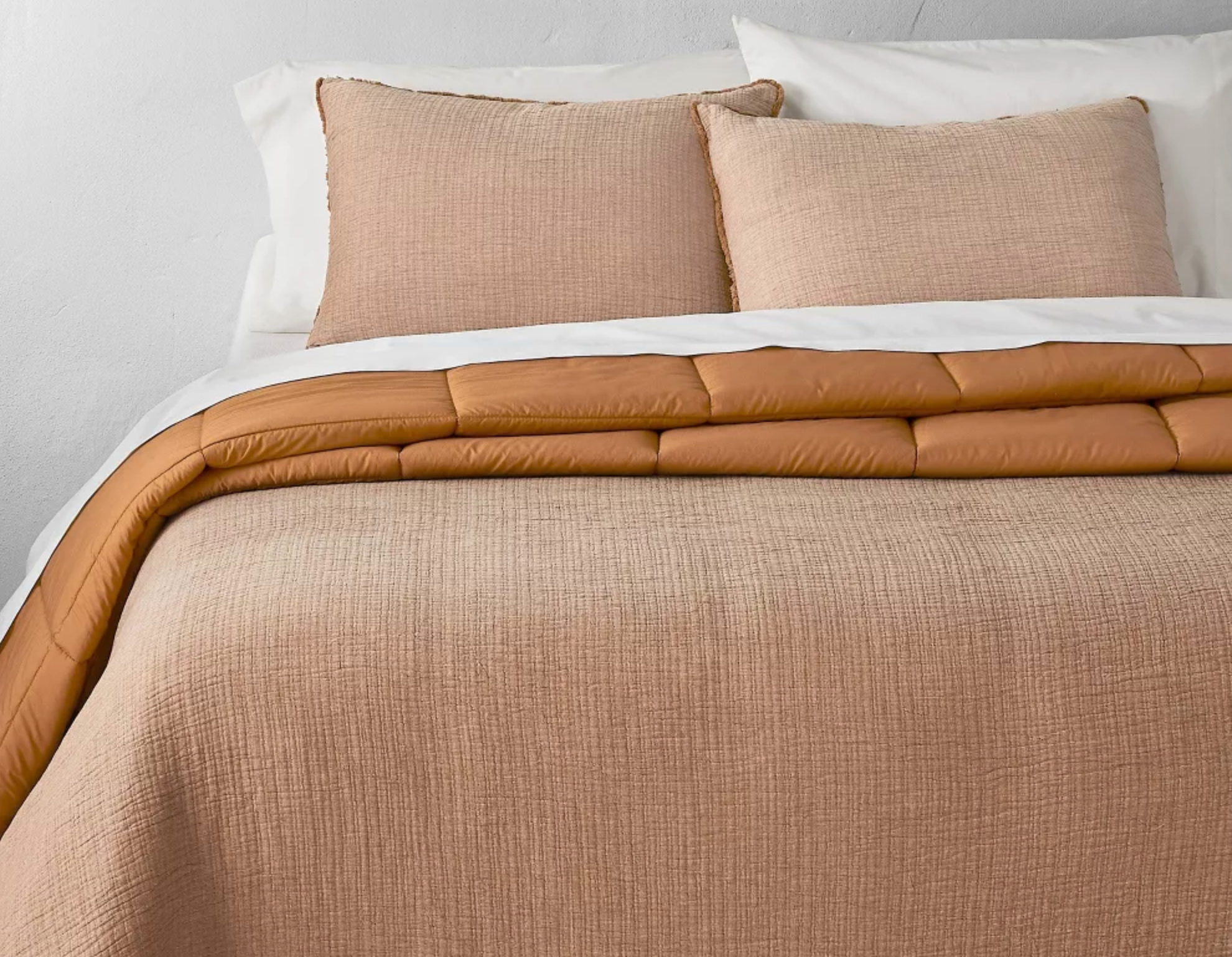 bed with an orange comforter on it